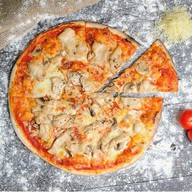 Пицца с ветчиной, курицей и грибами Фото