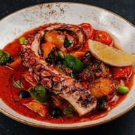 Осьминог с соусом из томатов и оливок Фото